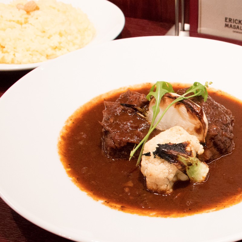 豪州産ラムのナヴァラン風煮込みと特徴的な2種のグレイヴィ 皿上で完成するカレー(エリックサウス マサラダイナー)の写真