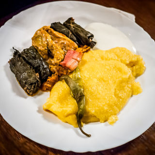 Mixed minced meat rolled in vine leaves served with polenta, sour cream and chili pepper  (Caru' cu bere)