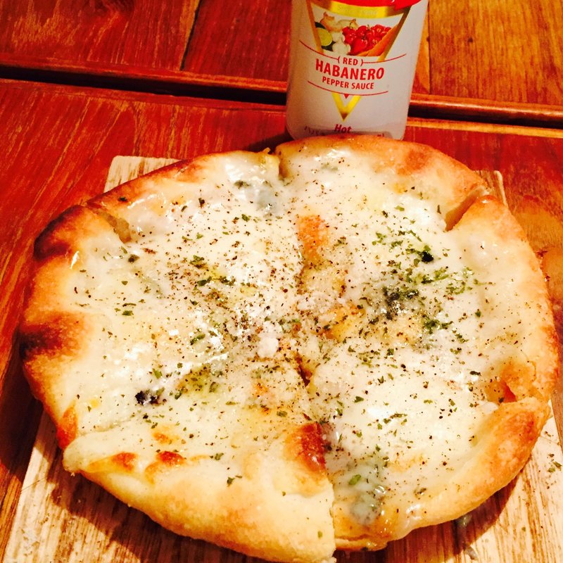 4種のチーズピッツァがっつりブラックペッパー仕上げ(煙　燻製バル　トリベーネ 心斎橋店 （ケムリクンセイバルトリベーネ）)