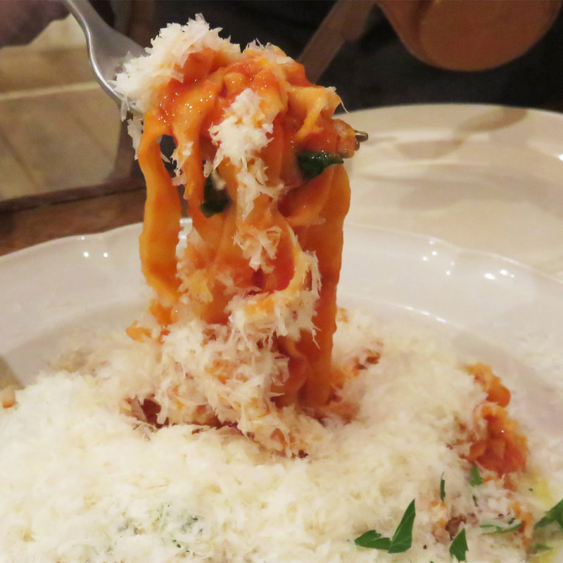 パルミジャーノチーズをたっぷりのせたタリアッテレのトマトソース(Ｉl Ｓol Levante)