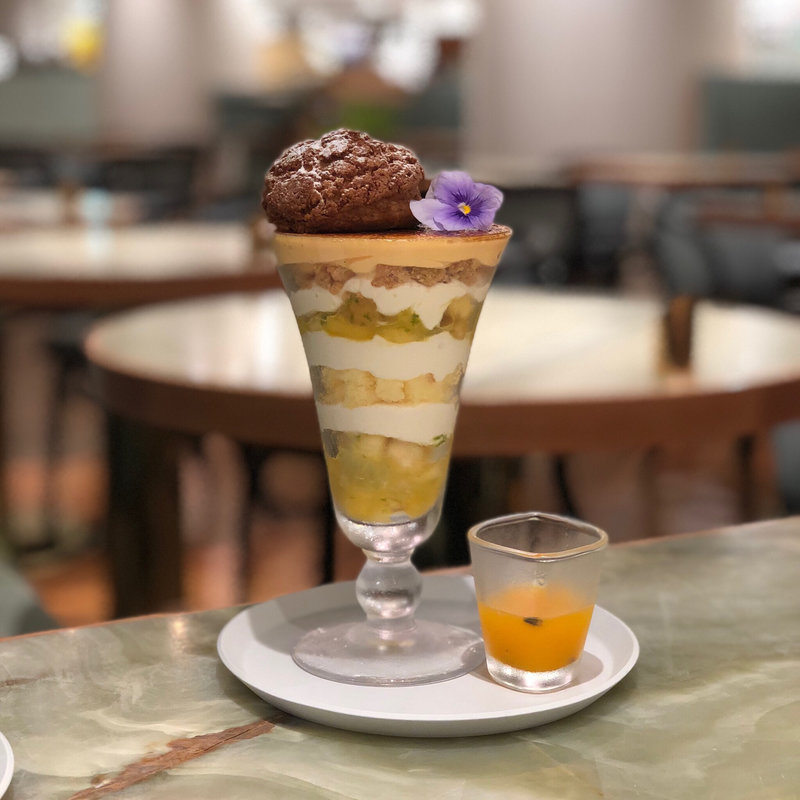 香ばしく焼き上げた大きなシュークリームを乗せた南国フルーツとフレッシュライムのブリュレパフェ(bistro cafe THE FLOWER TABLE)